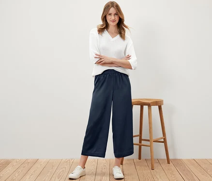 Frau posiert in marineblauer Satinhose.