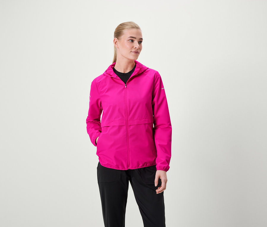 Frau trägt eine pinke Kapuzenjacke und schwarze Hosen.
