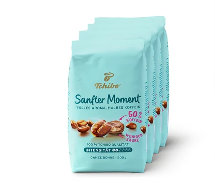Vier Packungen Tchibo Sanfter Moment Kaffee, jede mit der Aufschrift "50% Koffein".