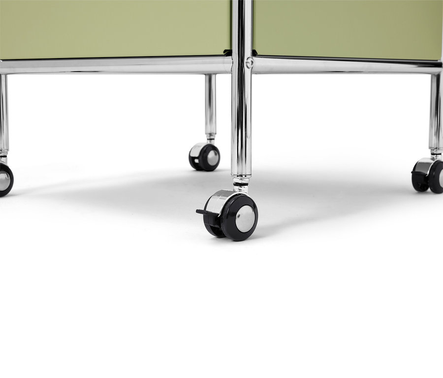 Nahaufnahme von einem hellgrünen rollbaren Regal mit verchromten Beinen auf einem weißen Hintergrund.
