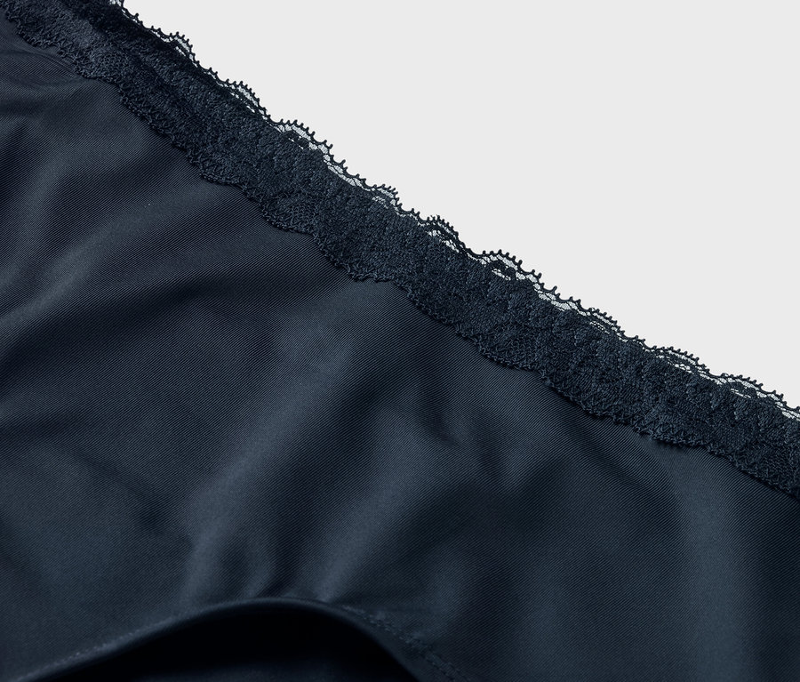 Nahaufnahme von marineblauer Unterwäsche mit Spitzenbesatz.