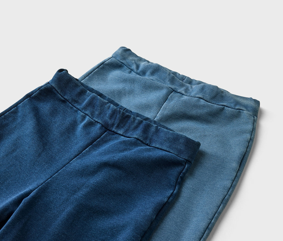 Nahaufnahme von zwei Jeanshosen in verschiedenen Blautönen, die übereinander liegen.