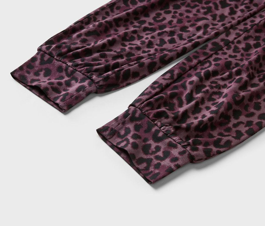 Nahaufnahme von Ärmeln mit Bündchen und Leopardenmuster in Lila und Schwarz.