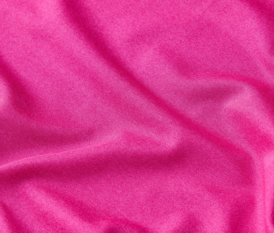 Nahaufnahme von drapiertem, pinkfarbenem Stoff.