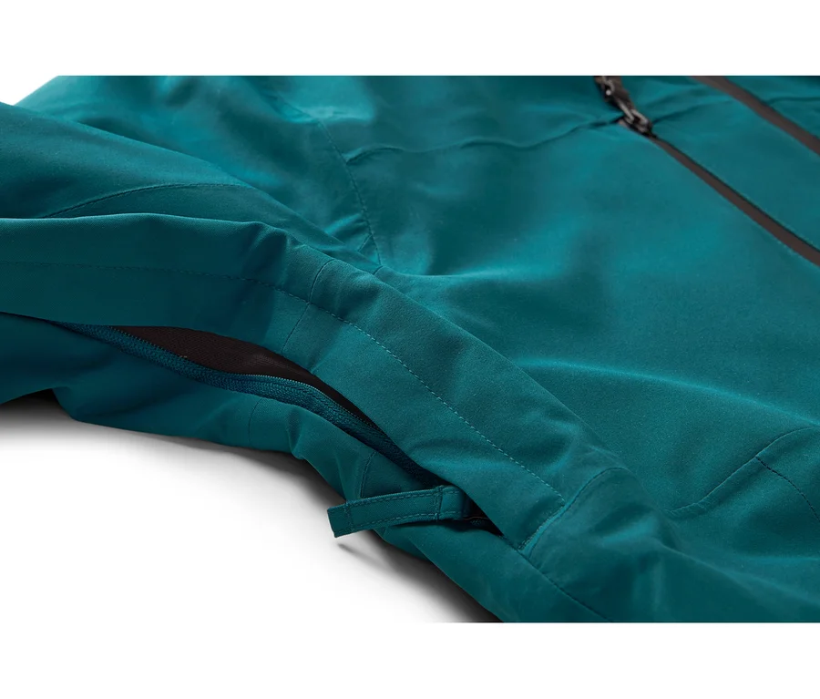 Nahaufnahme einer türkisfarbenen Jacke mit einem teilweise geöffneten Seitenreißverschluss, der dunkles Netzgewebe zeigt, und einem schwarzen Hauptreißverschluss oben.