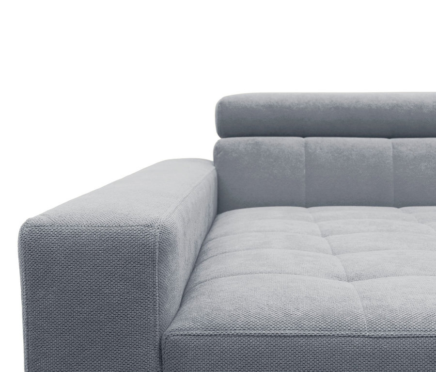 Nahaufnahme eines hellgrauen Sofas mit strukturiertem Stoff, sichtbarer Armlehne, gesteppter Sitzfläche und Rückenlehne mit Kopfstütze.